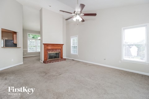 a living room with a fireplace and a ceiling fan