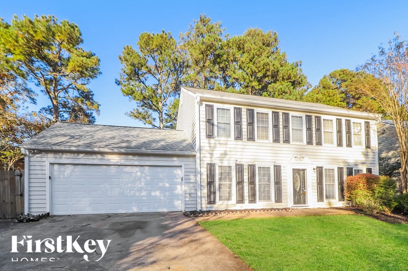 a white house with a white garage and a green lawn