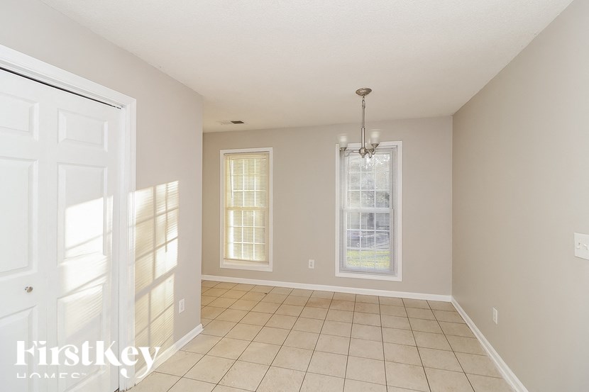 a empty living room with a white door and a window