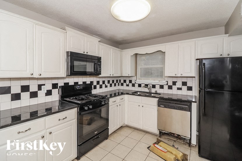 a kitchen with black appliances and white cabinets