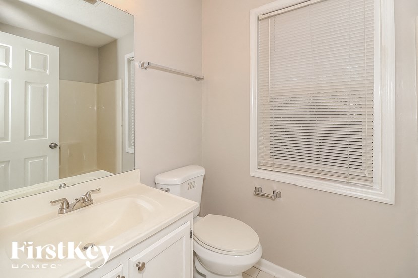 a bathroom with a toilet and a sink and a mirror
