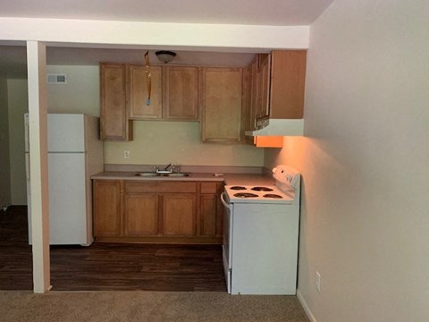 A kitchen with wooden cabinets and a white fridge.