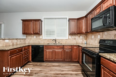 A kitchen with wooden cabinets and black appliances.