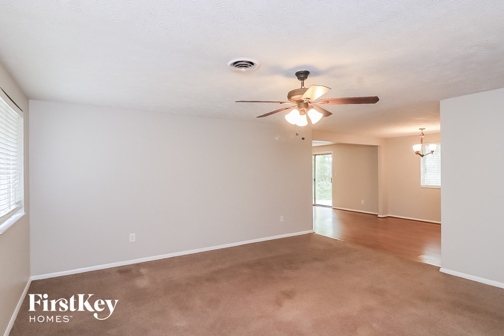 A spacious room with a ceiling fan and light fixture.