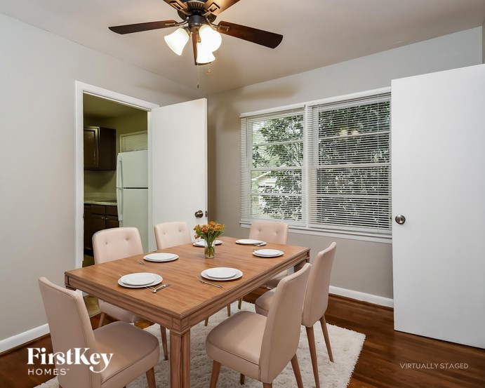 A dining room with a wooden table and chairs.