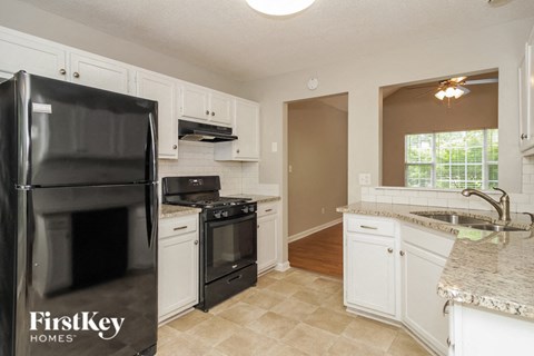 a kitchen with black appliances and white cabinets