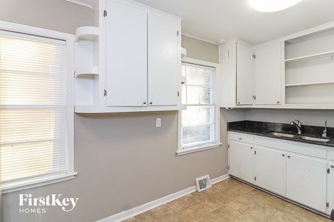 A kitchen with white cabinets and a sink.