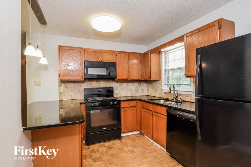 a kitchen with black appliances and wooden cabinets