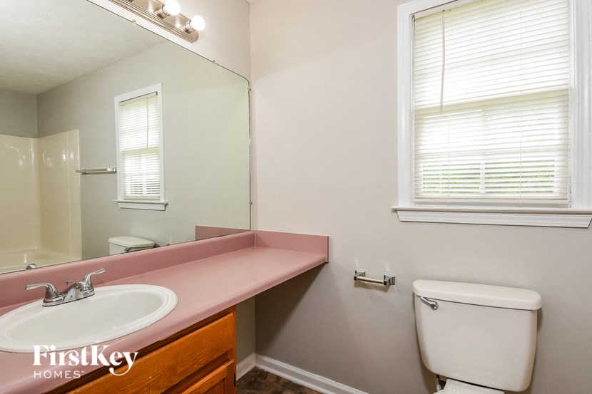 a bathroom with a toilet and a sink and a mirror