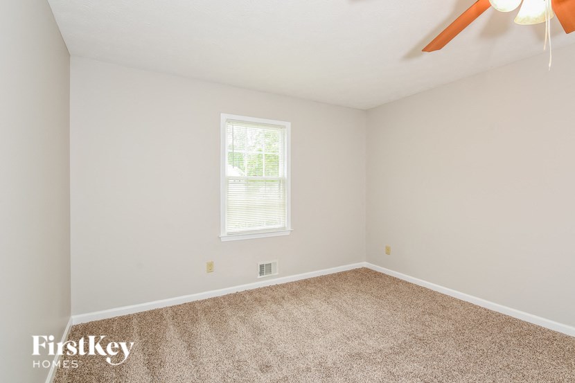 an empty room with a ceiling fan and a window