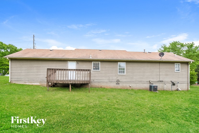 the front of a house with a yard and a deck