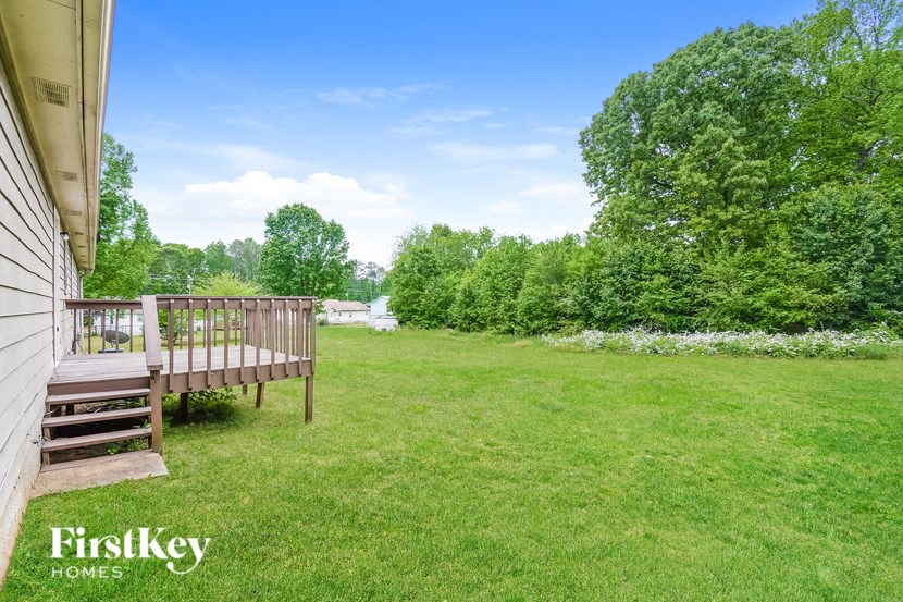 a backyard with a wooden bench in the grass