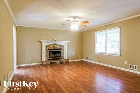 a living room with a fireplace and a ceiling fan