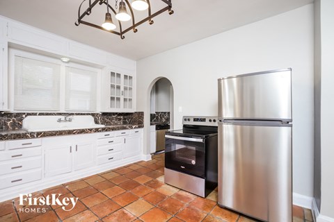 A kitchen with a stainless steel refrigerator and a black oven.