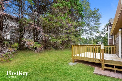 a backyard with a wooden bench in the grass