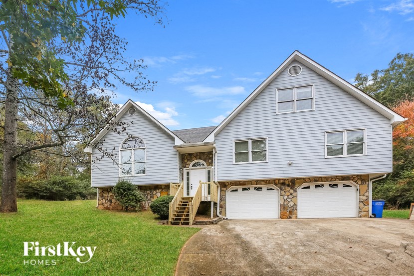 a white house with two garage doors and a driveway