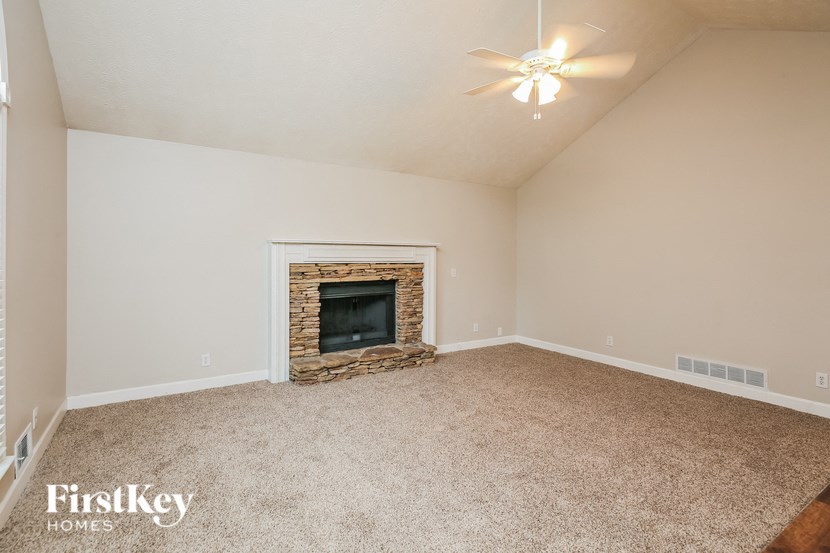 a living room with a fireplace and a ceiling fan