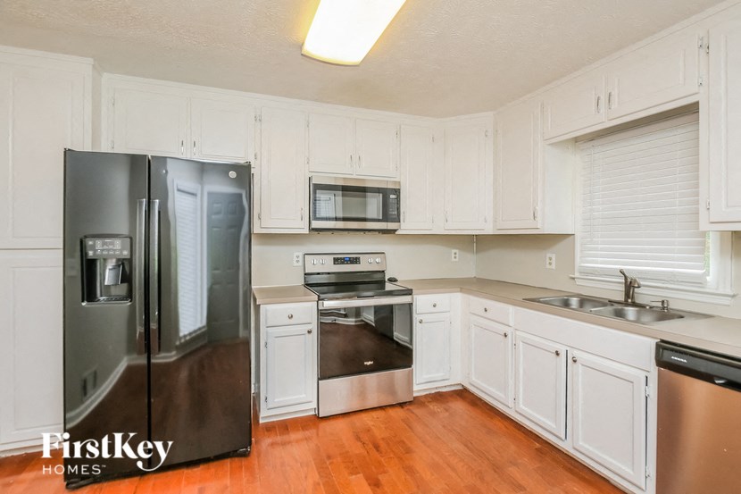 a kitchen with white cabinets and stainless steel appliances