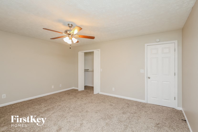a bedroom with a ceiling fan and a closet