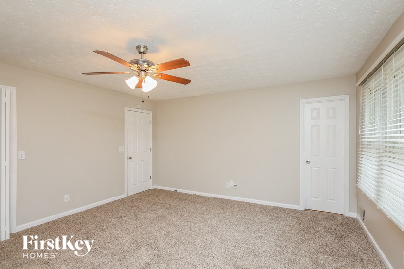 a bedroom with a ceiling fan and a window