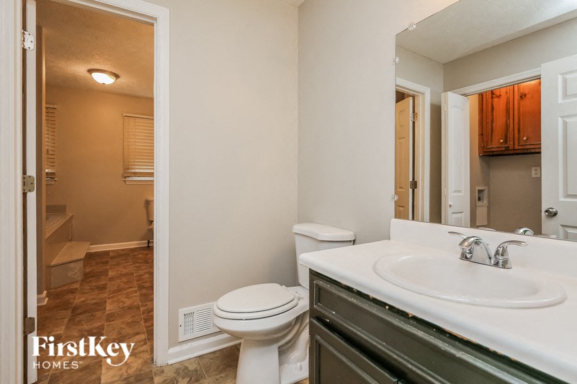 a bathroom with a toilet and a sink and a mirror