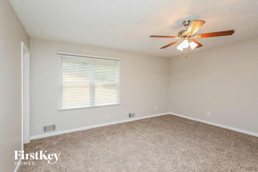 an empty room with a ceiling fan and a window
