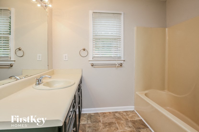 a bathroom with a sink and a tub and a mirror