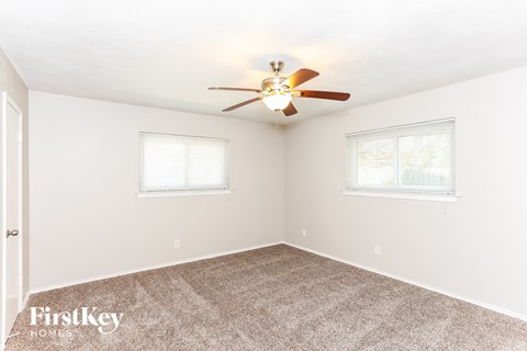 a bedroom with carpet and a ceiling fan