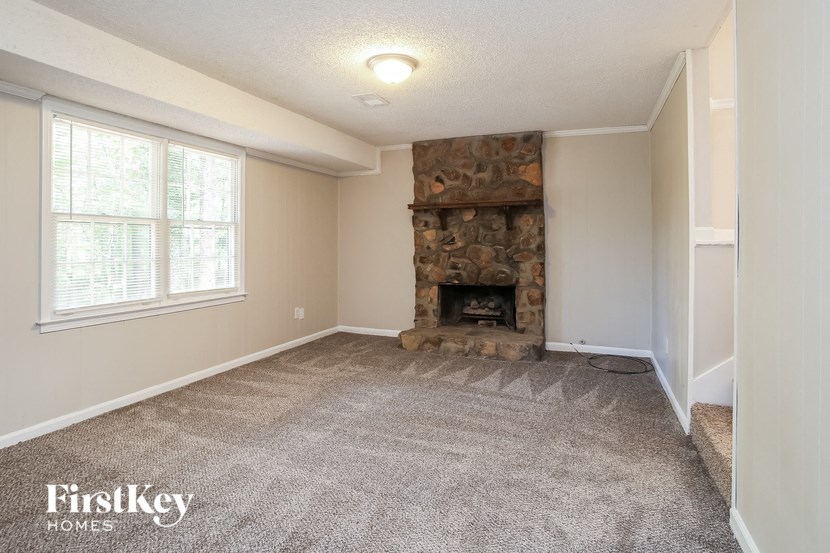 a living room with a fireplace and a carpeted floor