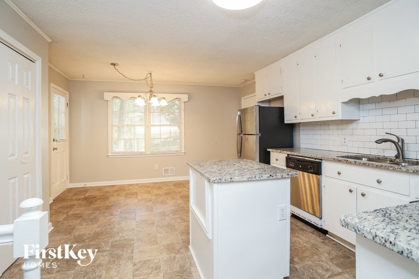 an empty kitchen with white cabinets and a counter top