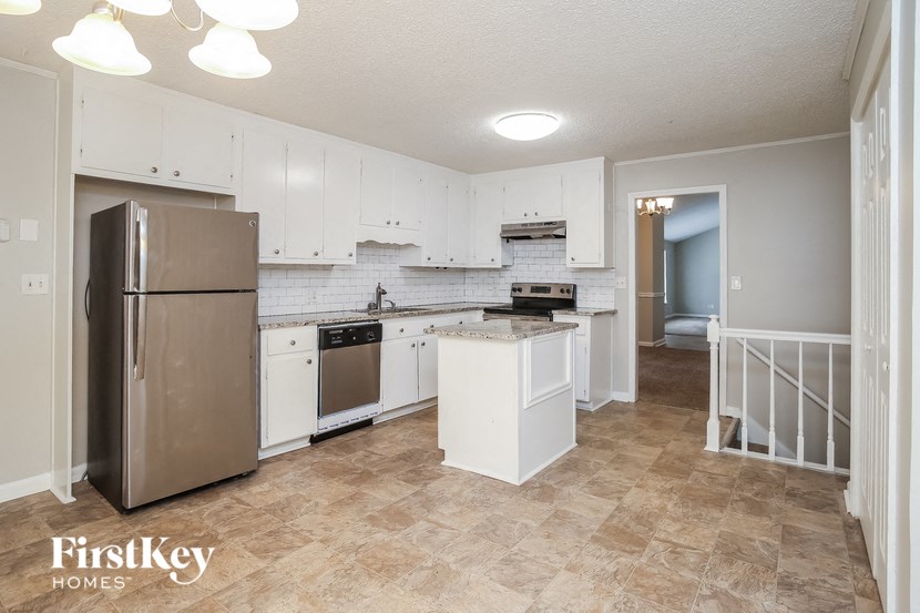 a white kitchen with stainless steel appliances and white cabinets