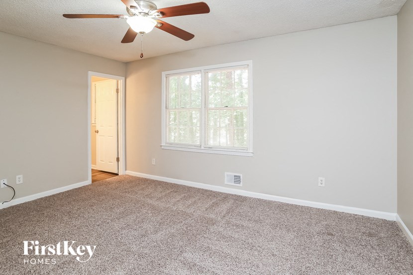 the living room of an empty house with a ceiling fan