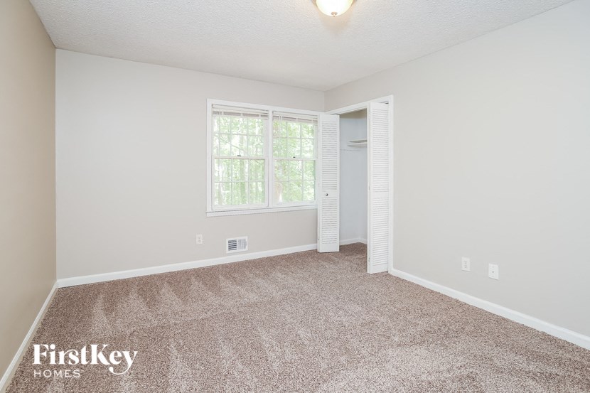 an empty living room with carpet and a window