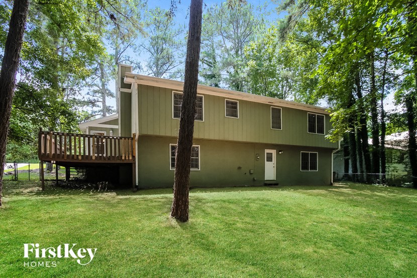 a green house with a yard and a deck