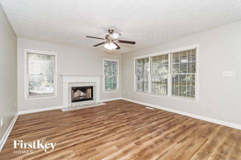 A spacious room with a fireplace and a ceiling fan.