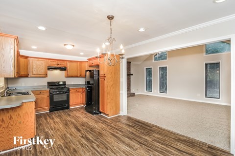 A kitchen with wooden cabinets and a black stove top oven.
