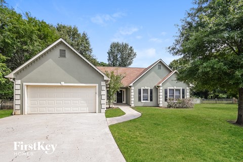 a gray and with a driveway and a garage door