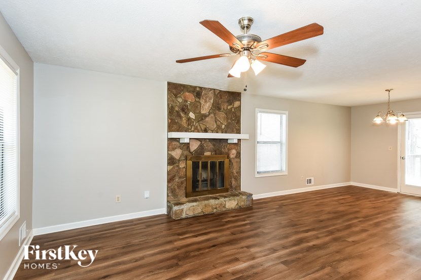 A spacious room with a fireplace and a ceiling fan.
