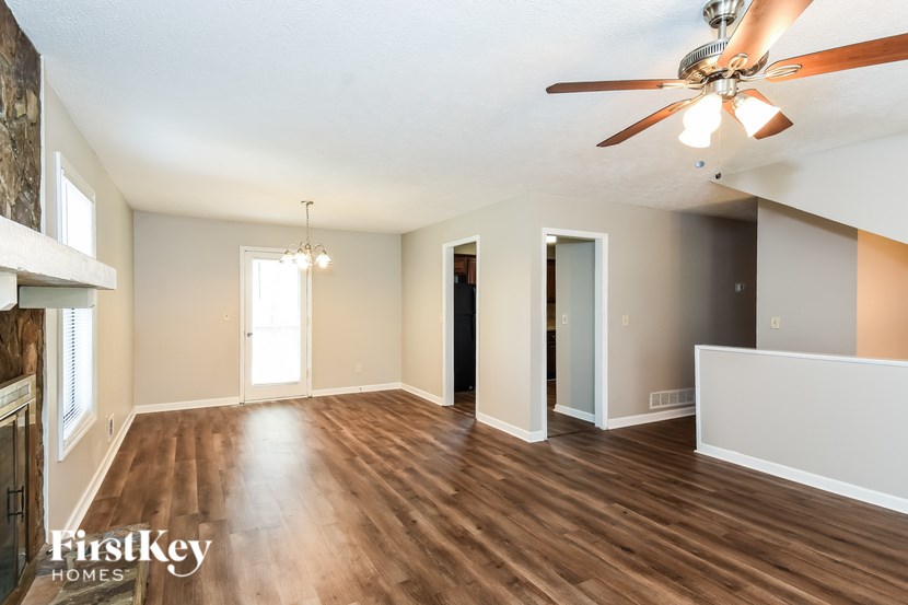 A spacious room with a ceiling fan and wooden flooring.