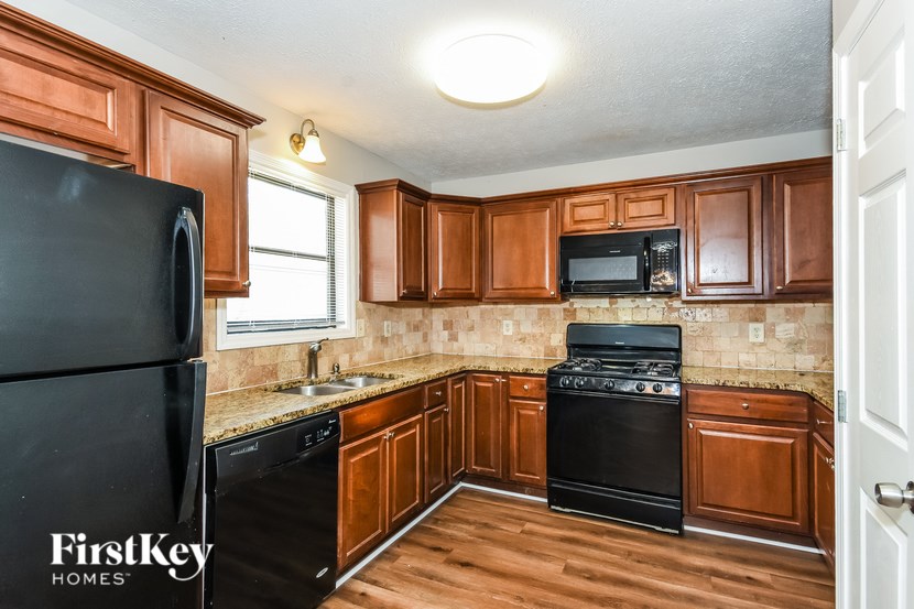 A kitchen with wooden cabinets and black appliances.