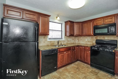 a kitchen with black appliances and wooden cabinets