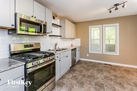 A kitchen with a stove top oven, microwave, and dishwasher.