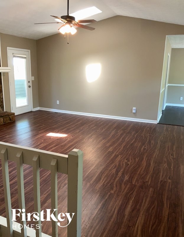 A room with wooden floors and a ceiling fan.