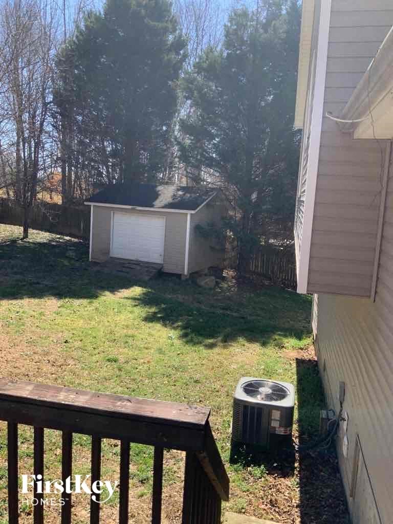 A small house with a white garage door is visible from a balcony.