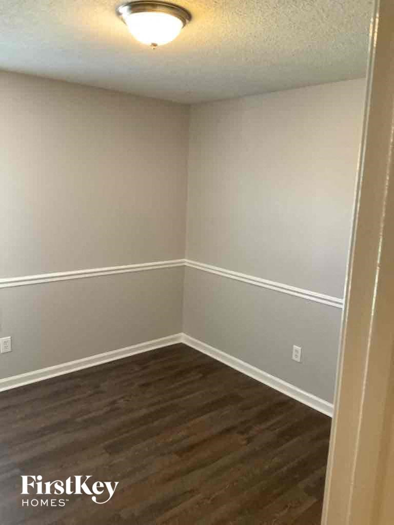A room with wooden flooring and a FirstKey Homes logo.