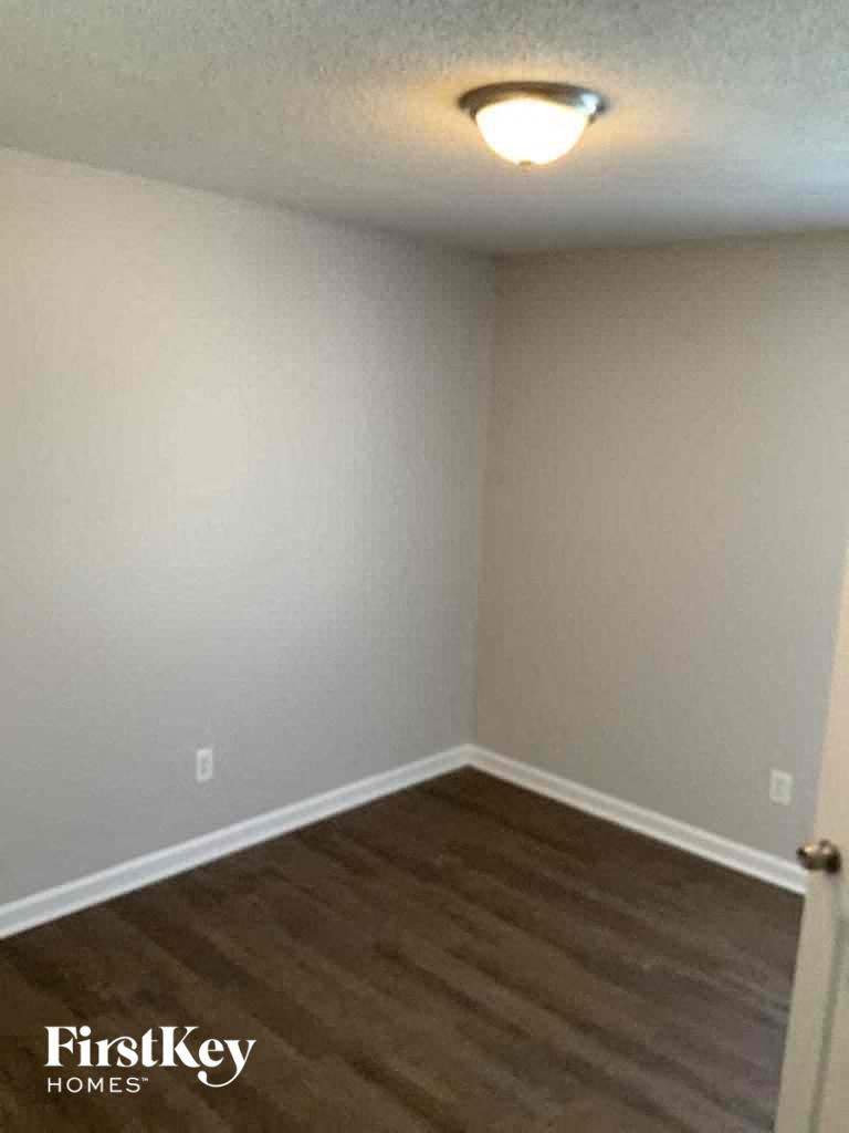 A room with a light on the ceiling and a door on the right.