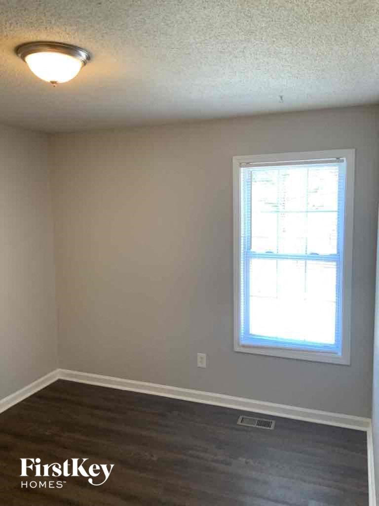 A room with a window and a wooden floor.