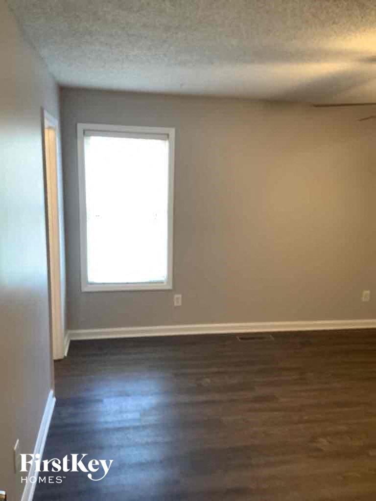 A room with a window and wooden floors.