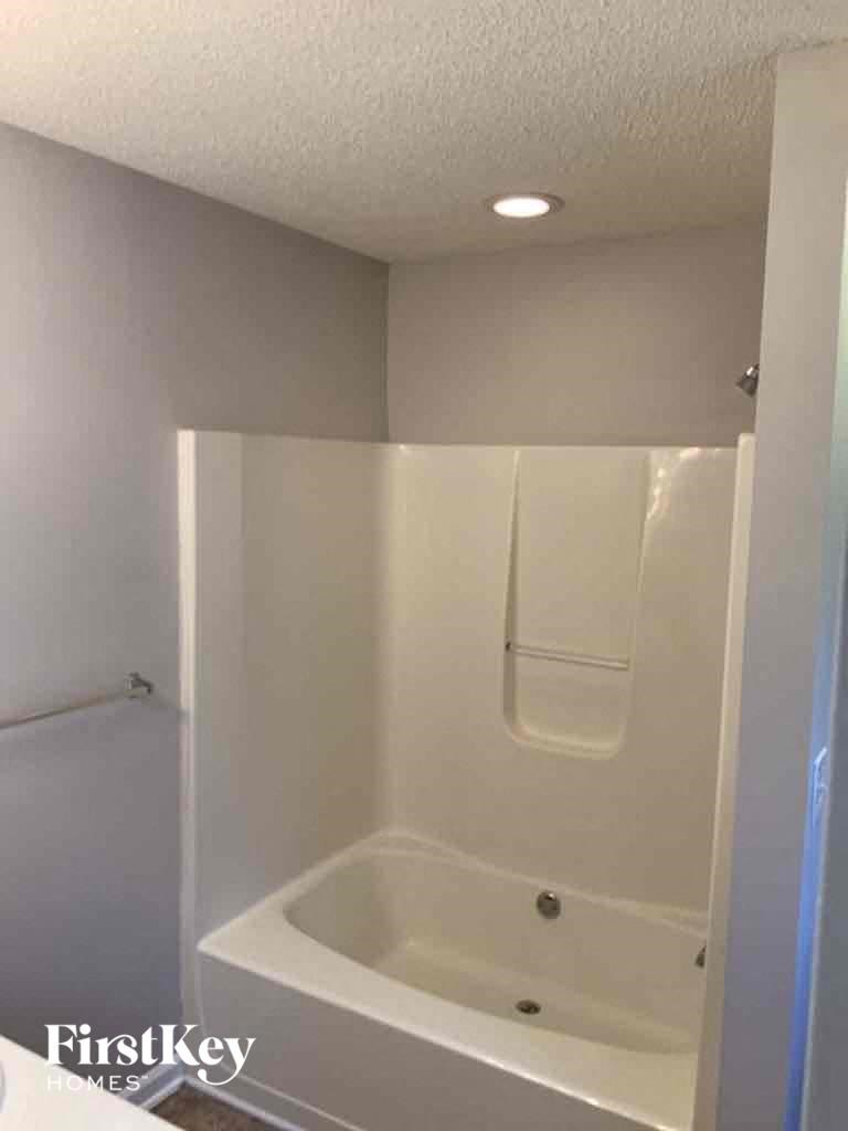 A white bathroom with a tub and a shower.