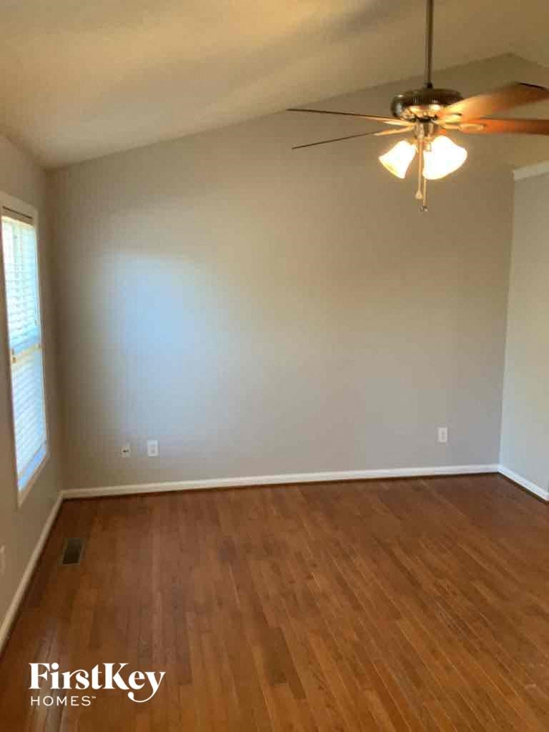 A room with wooden floors and a ceiling fan.